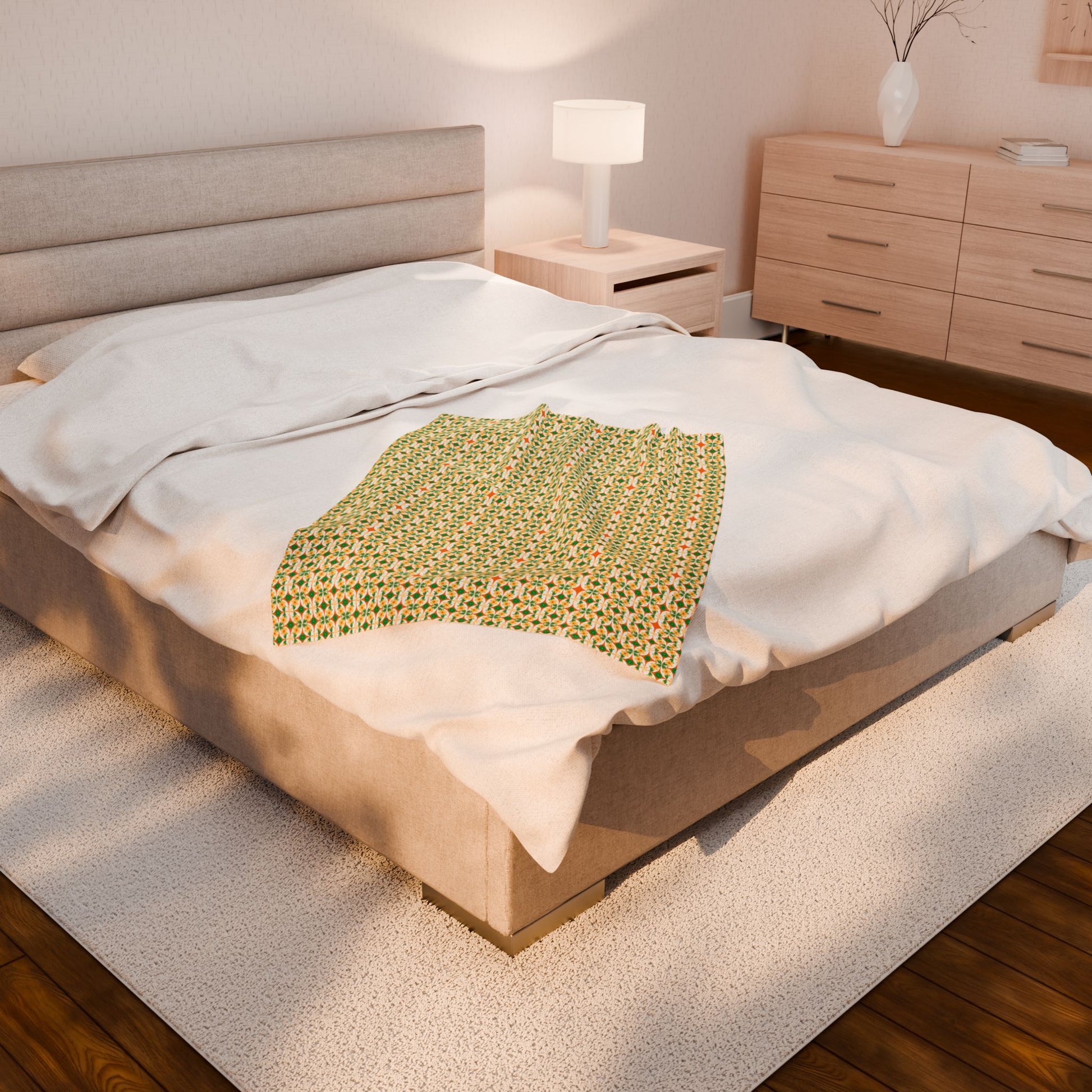 Bed with a green patterned blanket in a bedroom setting