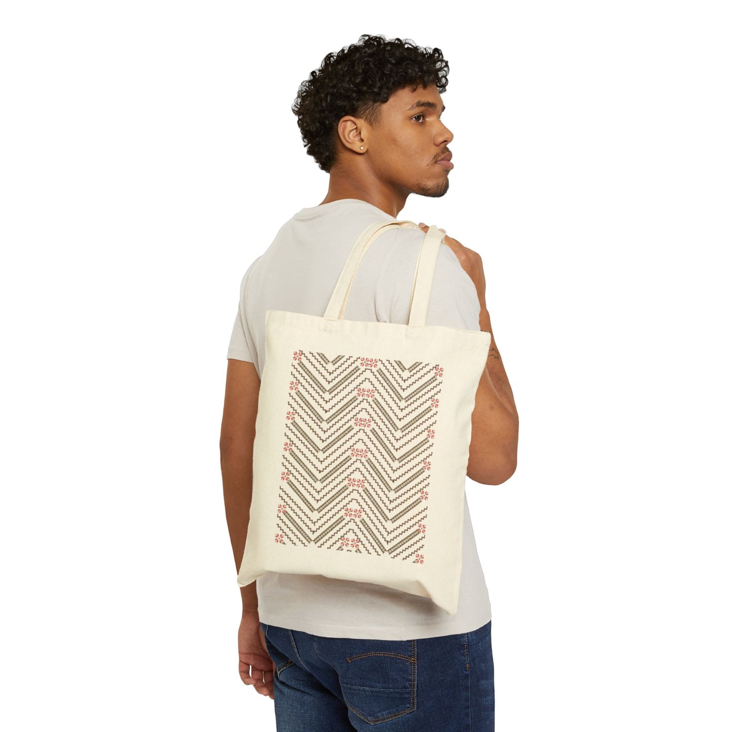 Person carrying a tote bag with geometric design on a white background