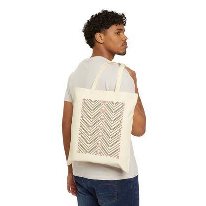 Person carrying a tote bag with geometric design on a white background