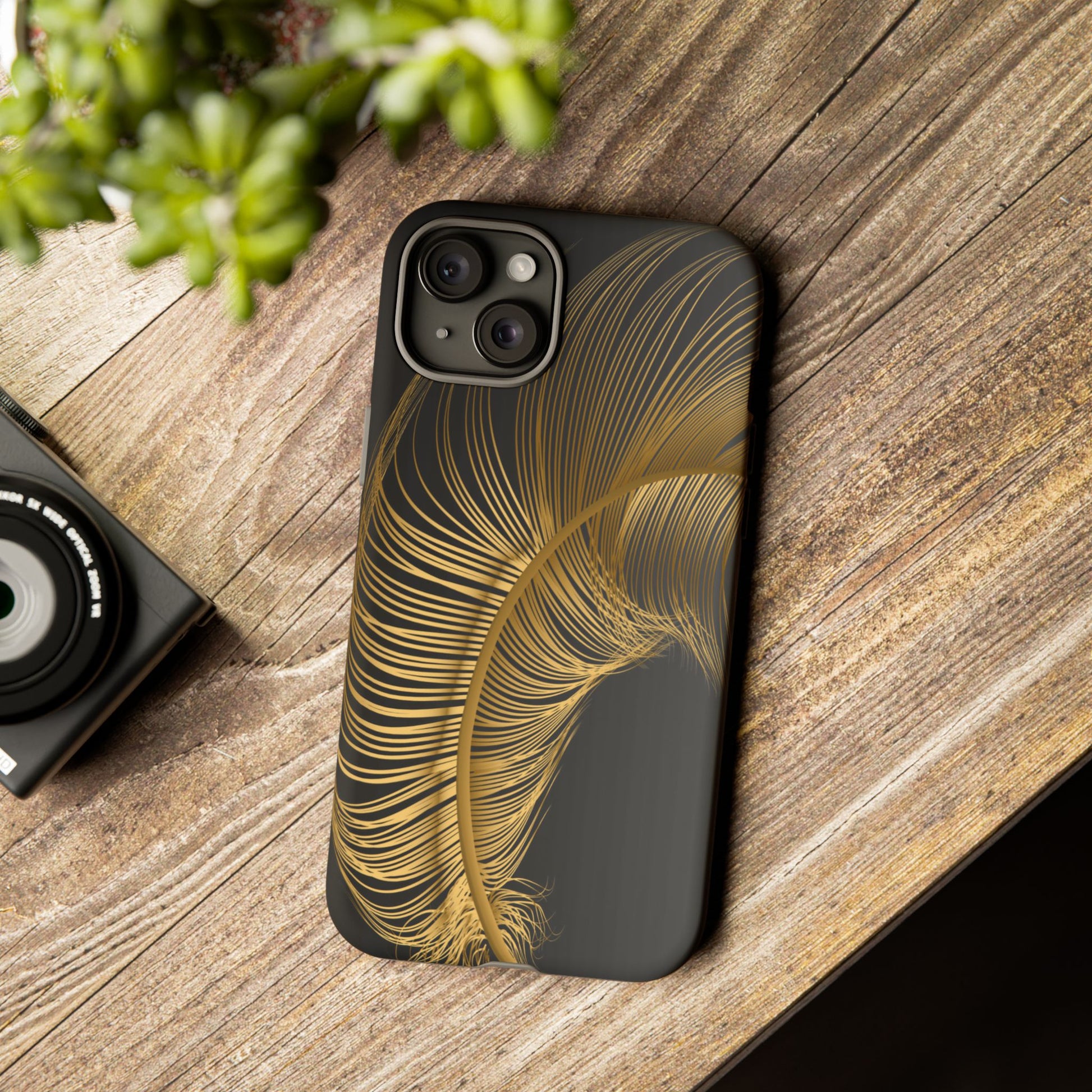 Phone case with gold feather design on black background