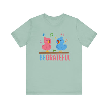 T-shirt with “Be Grateful” text and two bird illustrations – inspirational and nature-themed design for everyday wear.