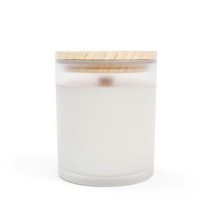 A frosted glass candle with a wooden wick and a label that includes hearts and text indicating it is made with coconut soy blended wax, hand-poured in the USA.