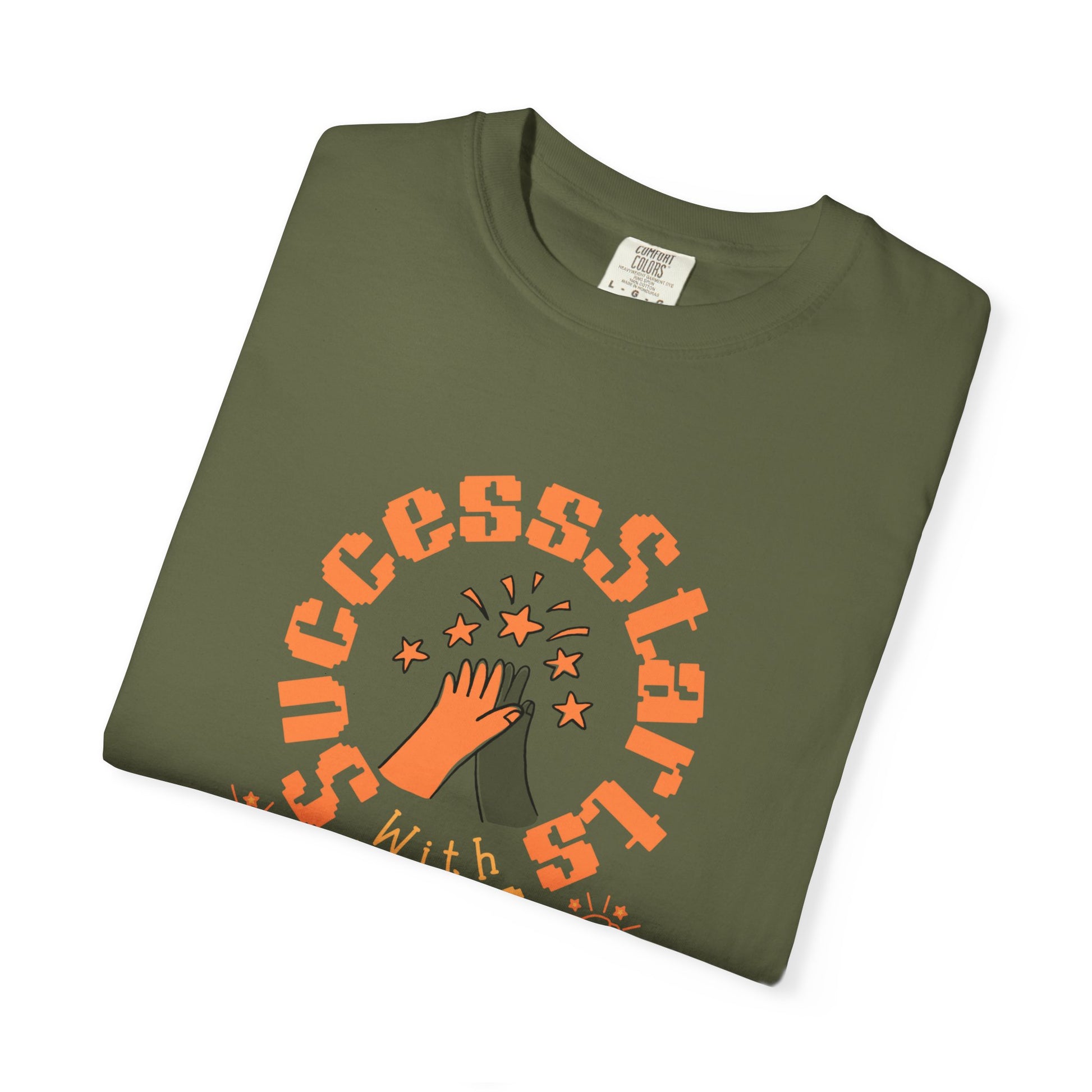 Folded green t-shirt with orange graphic and text on a white background