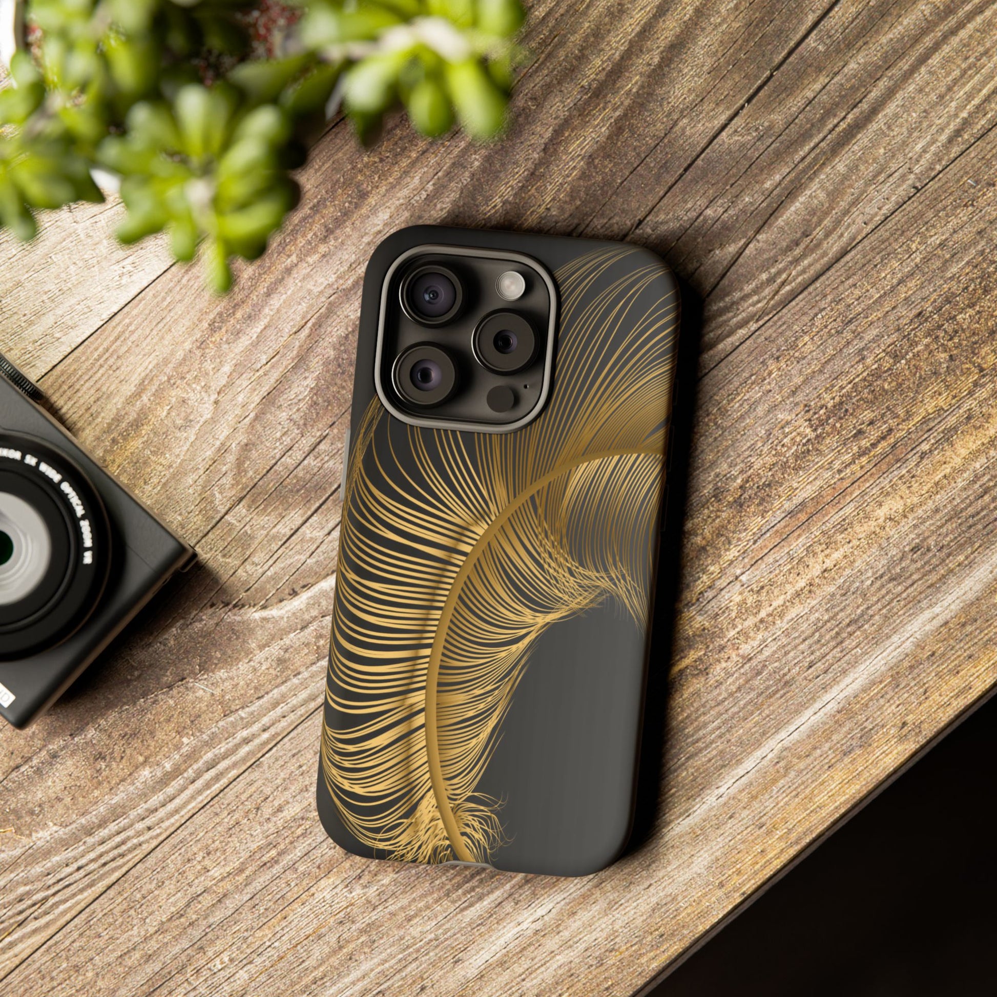 Phone case with gold feather design on black background