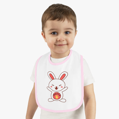 Child wearing a bib with a cartoon rabbit design on a plain background