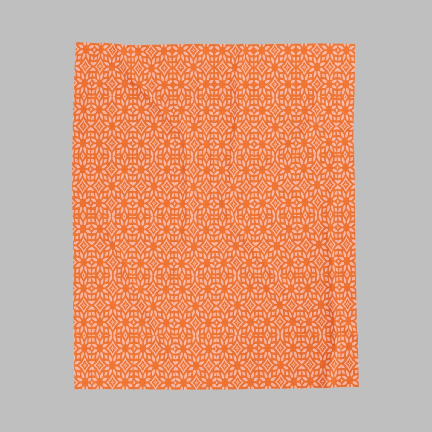 A plush orange blanket with a white pattern, displayed flat.