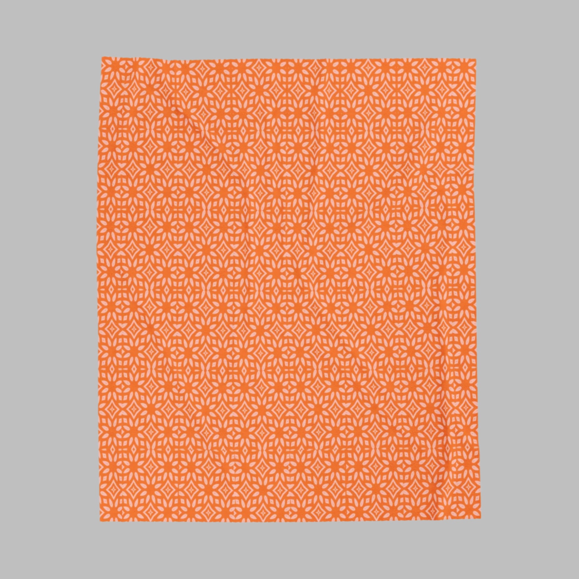 A plush orange blanket with a white pattern, displayed flat.
