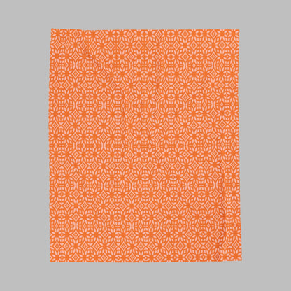 A plush orange blanket with a white pattern, displayed flat.