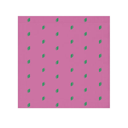A pink face towel with a pattern of small, green leaf-like shapes distributed evenly over the surface.

