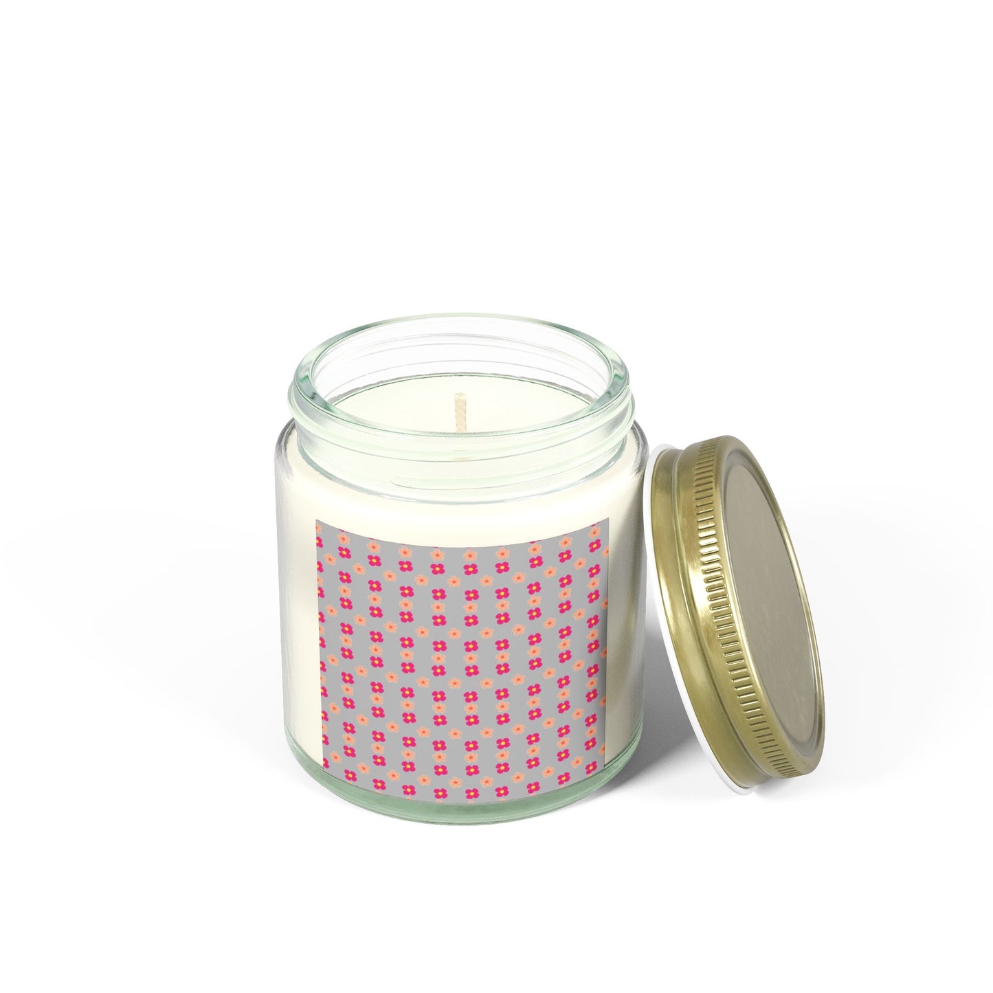 Candle in a glass jar with a pink patterned label on a white background.