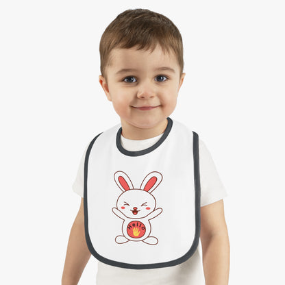 Child wearing a white bib with a cartoon rabbit design on a plain background