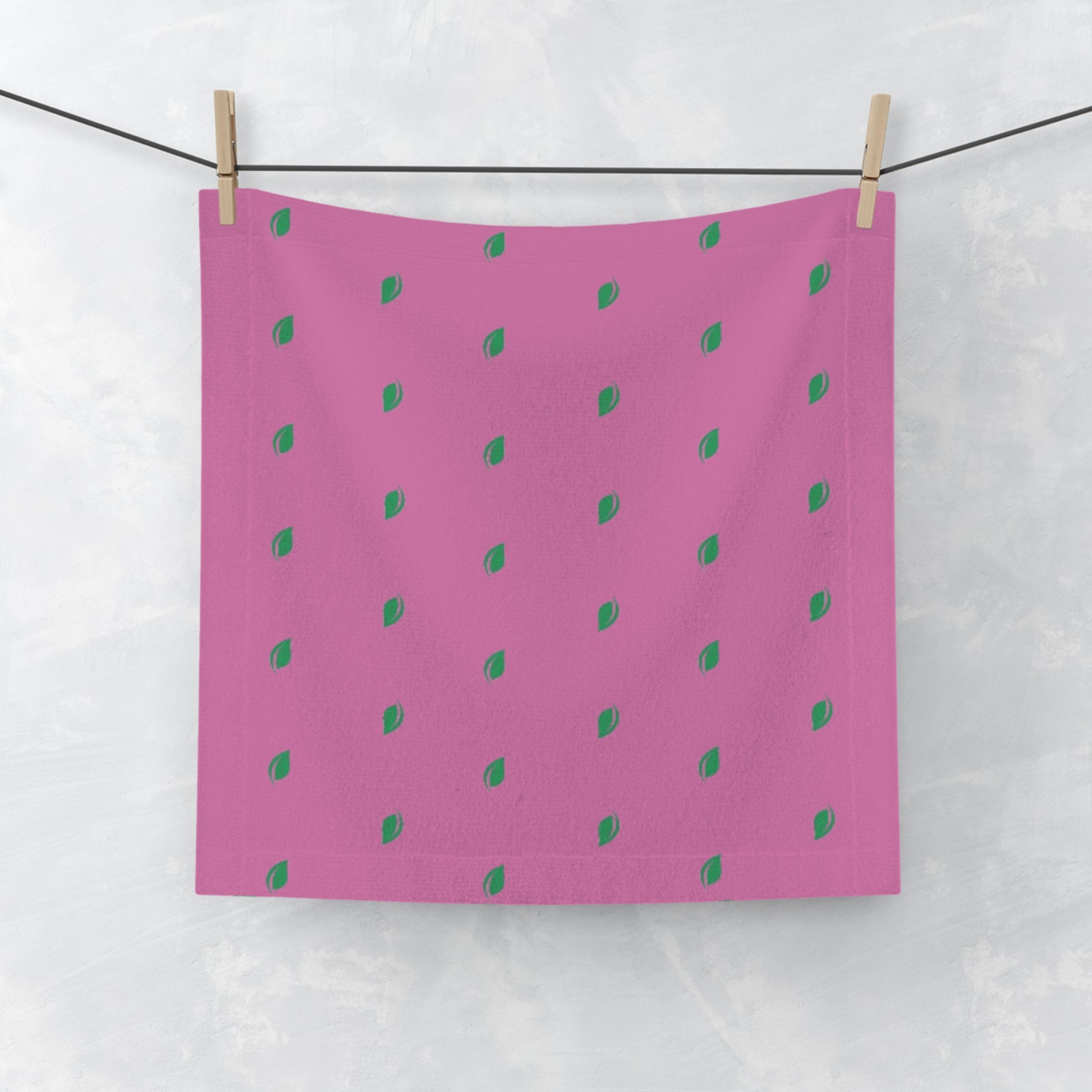 Pink fabric with green dot pattern hanging on a line.