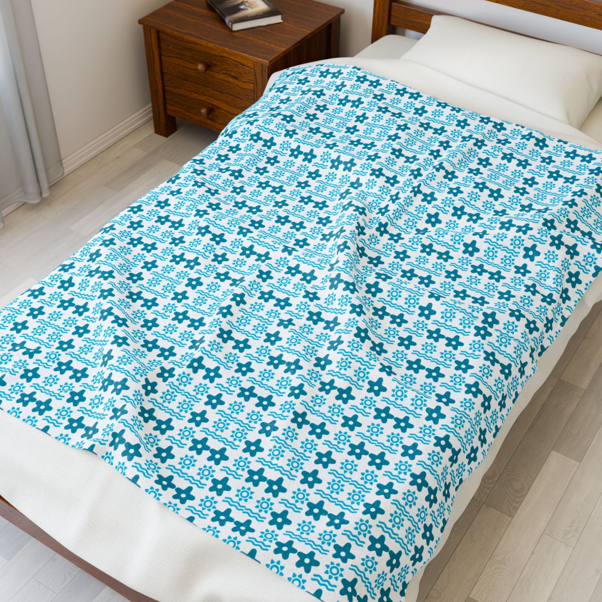 Bed with a blue and white patterned comforter in a bedroom setting.