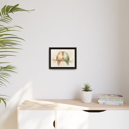 Framed artwork of two birds on a branch above a desk with a plant and books.