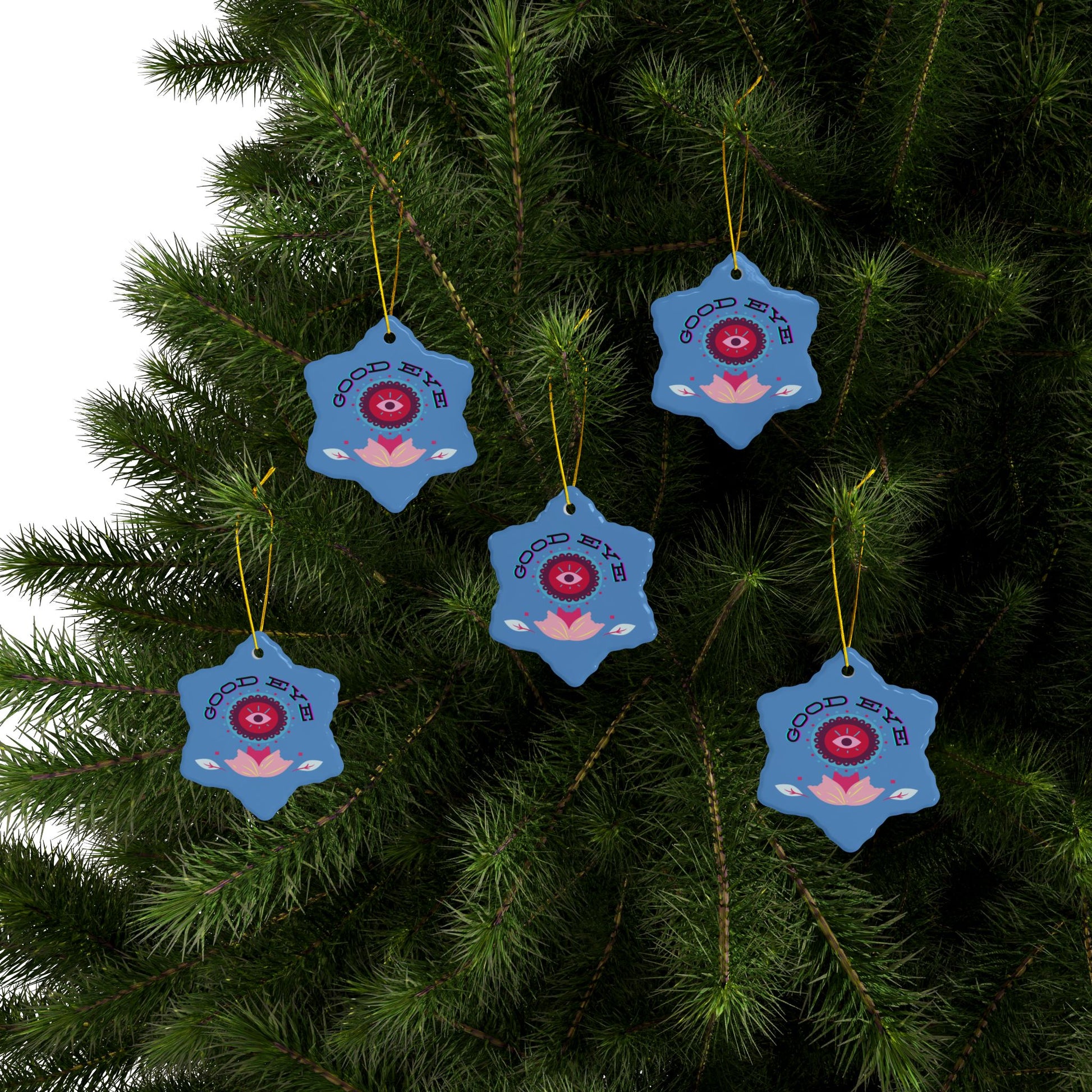 Blue decorative ornaments with red eye design hanging on a tree.