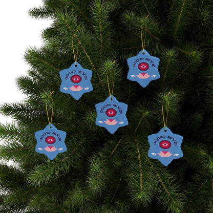 Blue decorative ornaments with red eye design hanging on a tree.
