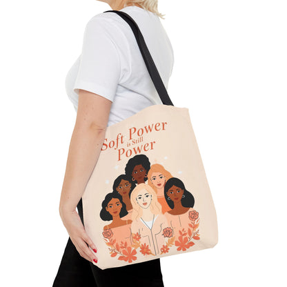 Man carrying a tote bag with a design of diverse women on a white background