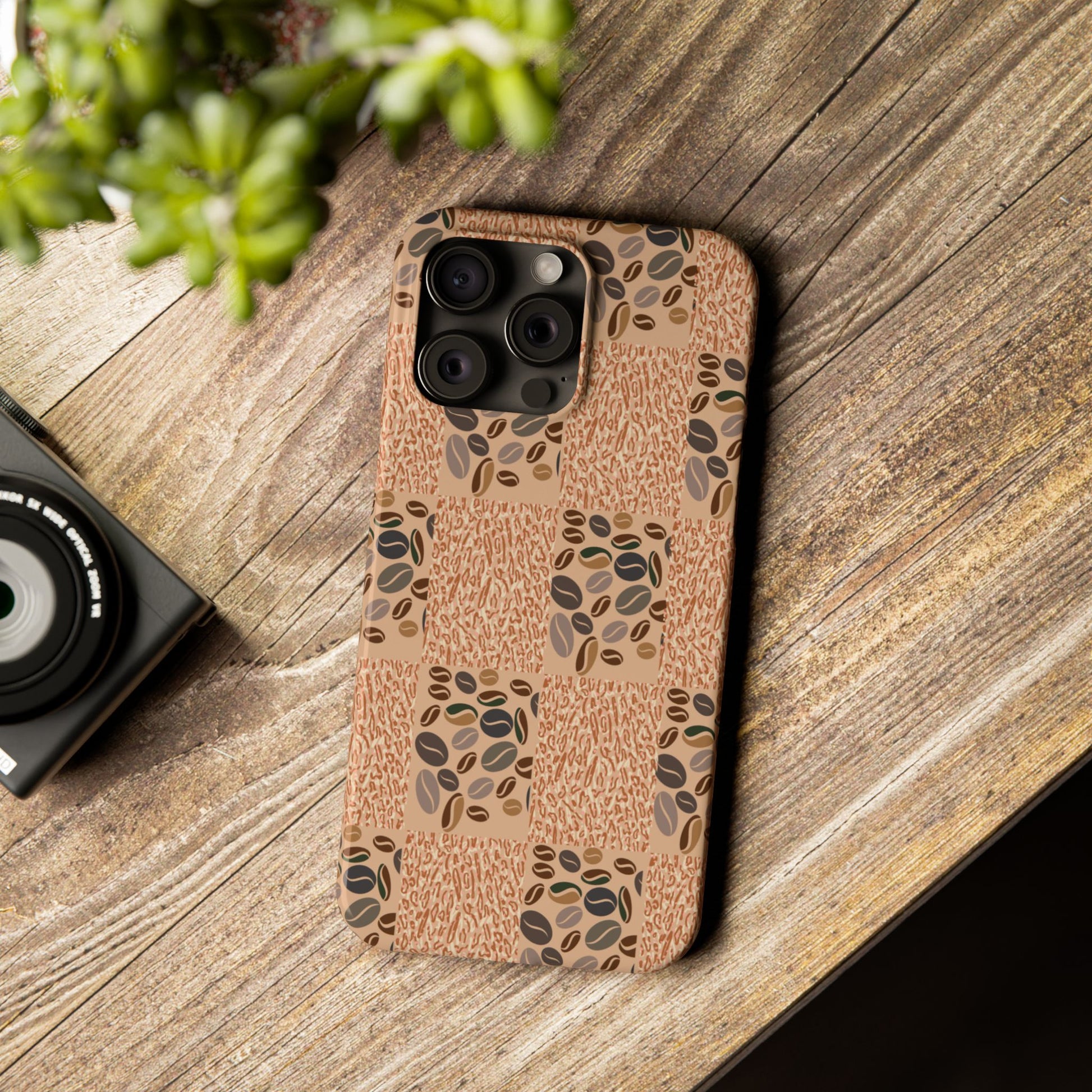 Phone case with coffee bean pattern on wooden surface.