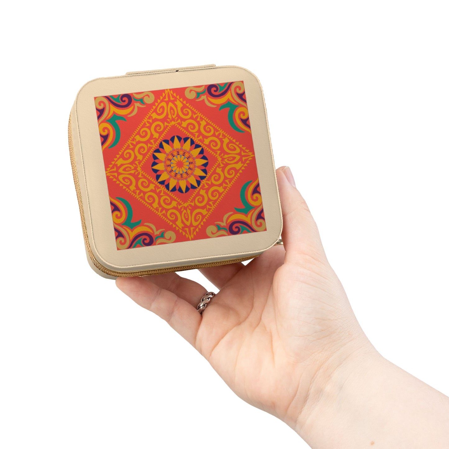 Hand holding a small square travel jewelry case with a colorful pattern on a white background