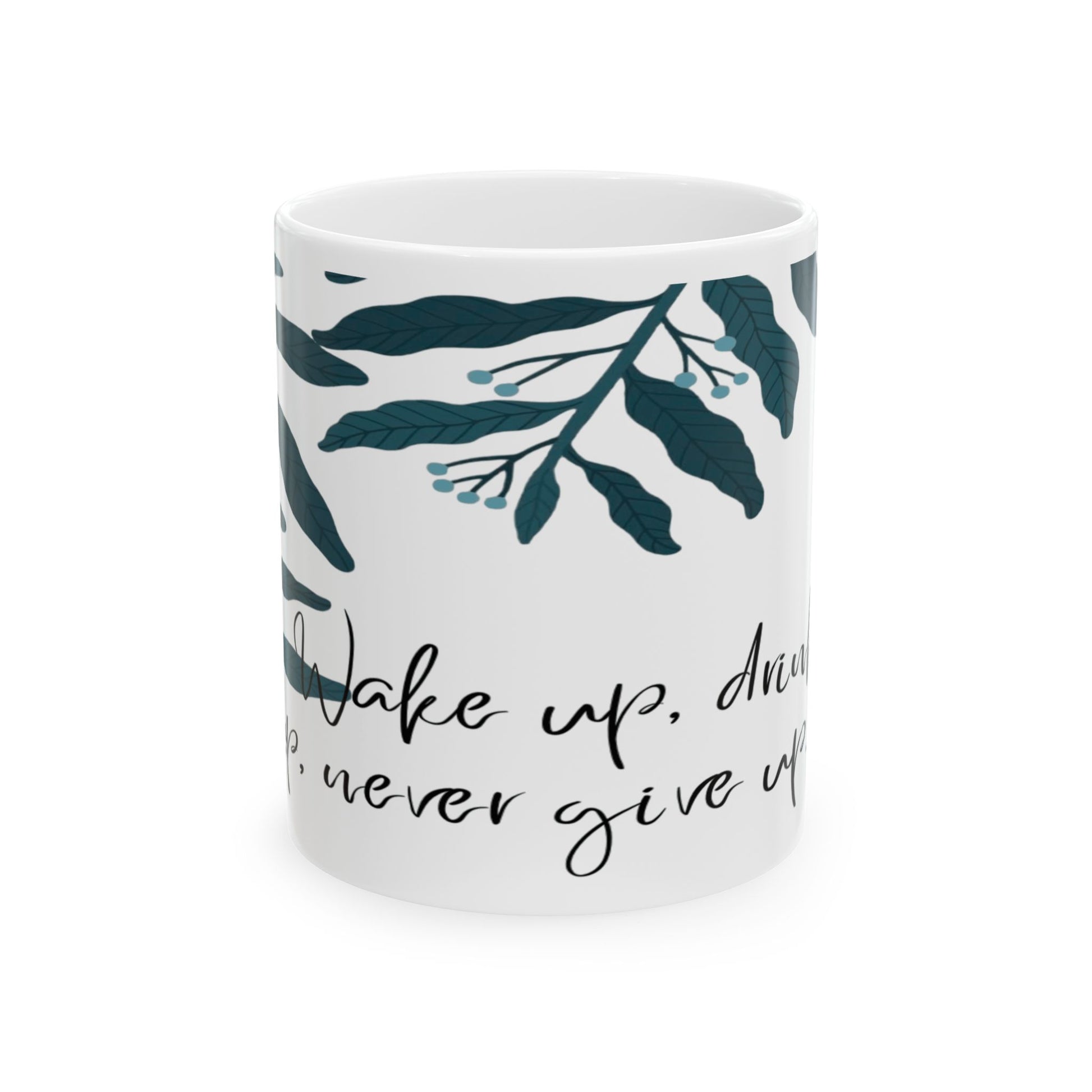 White ceramic mug with green leaf patterns and text that reads 'Take up, dream, never give up'.