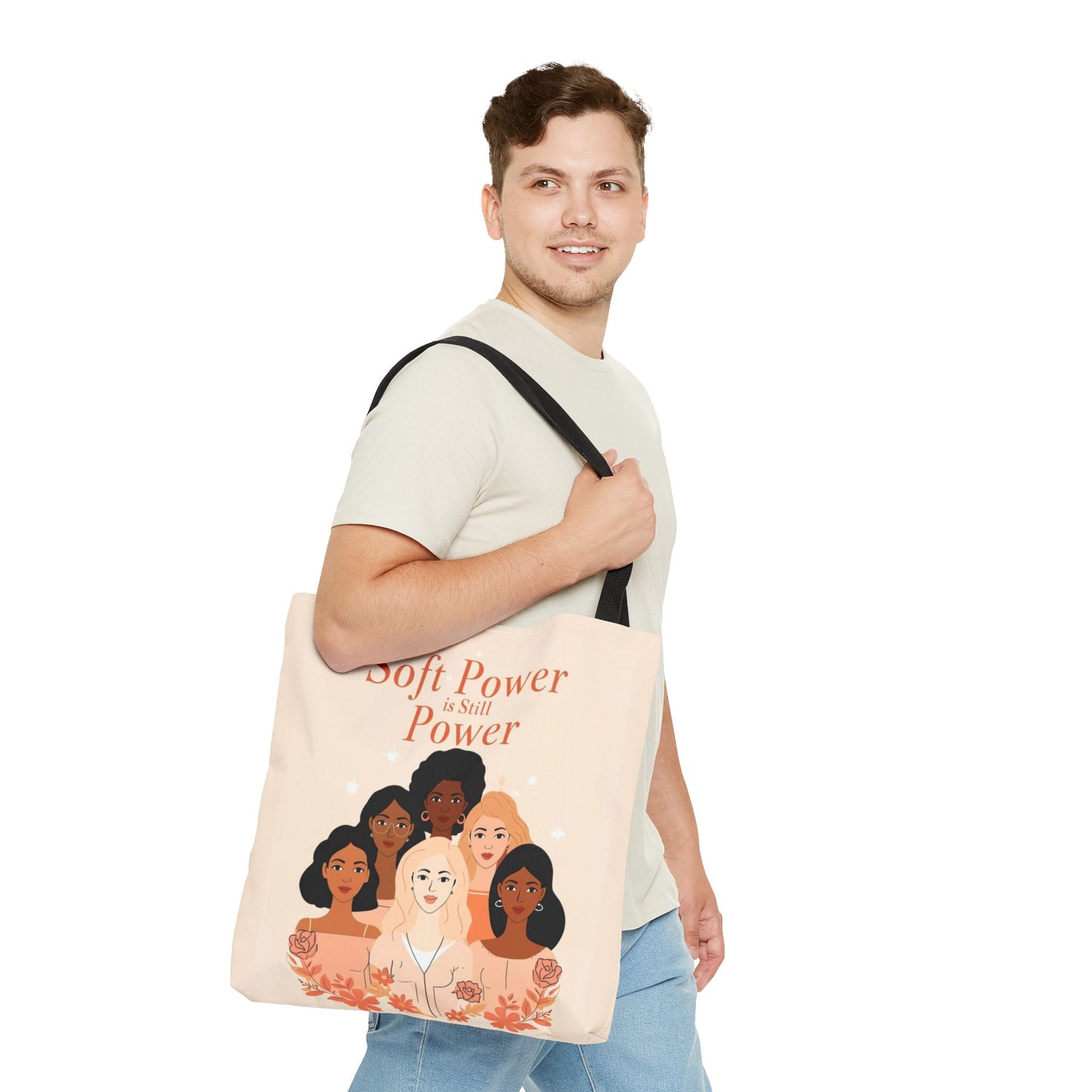Man holding a tote bag with illustrations of diverse women and text on a white background