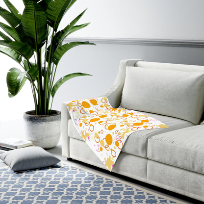 Light gray sofa with a colorful patterned blanket in a living room setting.