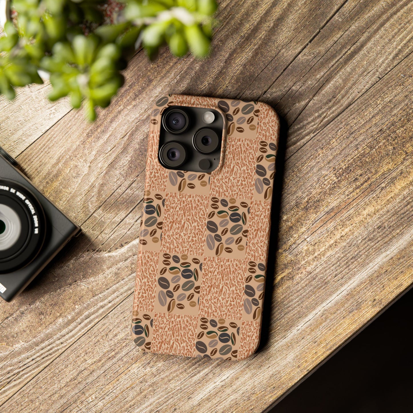 Phone case with coffee bean pattern on wooden surface.