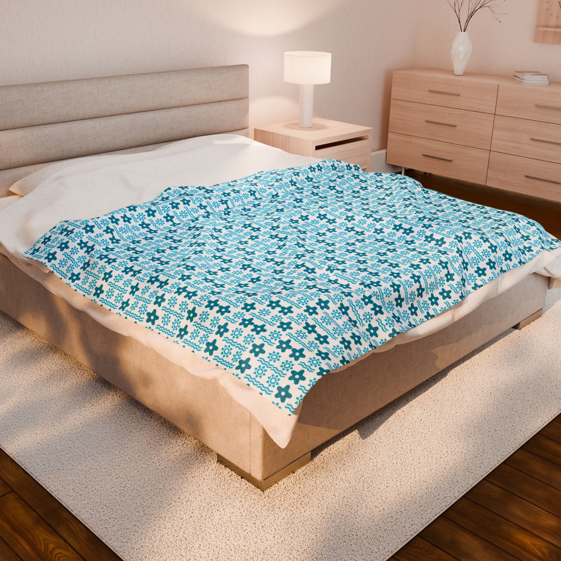 Bed with blue patterned blanket in a bedroom setting