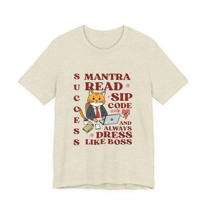 Beige t-shirt with a graphic of a cat in a suit and text on a white background